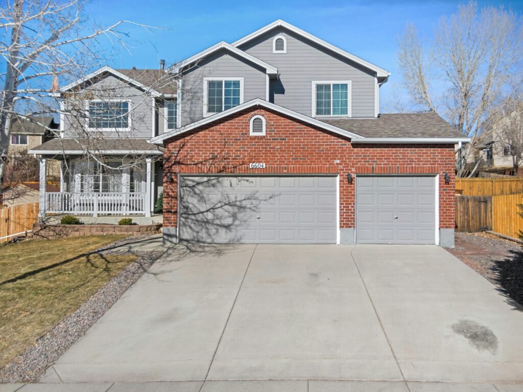 a two story house with a driveway in front of it